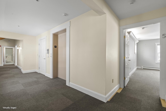 hallway with baseboard heating, dark carpet, elevator, and baseboards