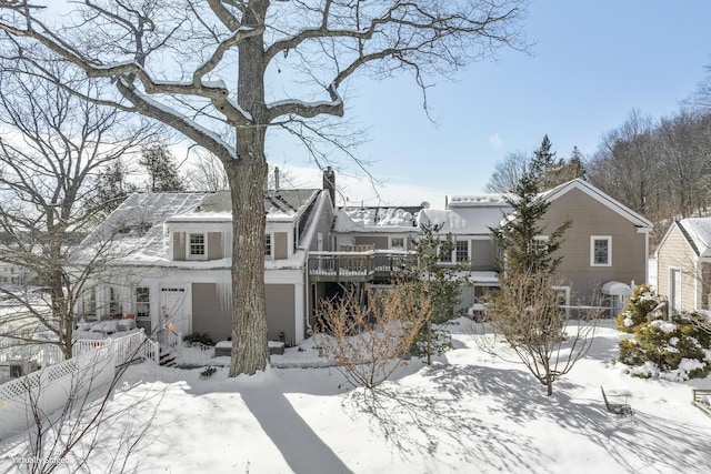 view of front of home featuring a chimney, fence, and a wooden deck