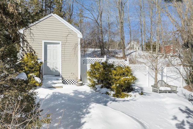 snow covered structure featuring fence