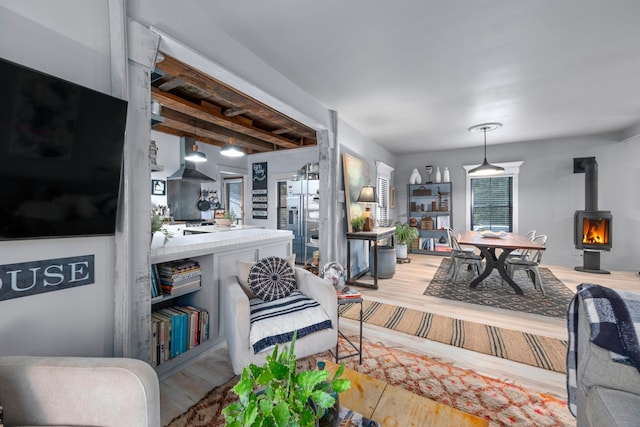 living room with light hardwood / wood-style flooring and a wood stove