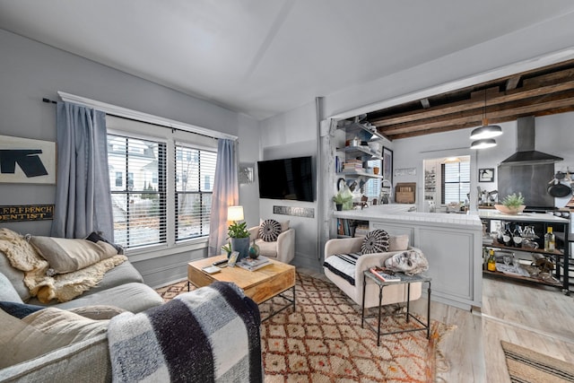 living room featuring beamed ceiling and light wood-type flooring