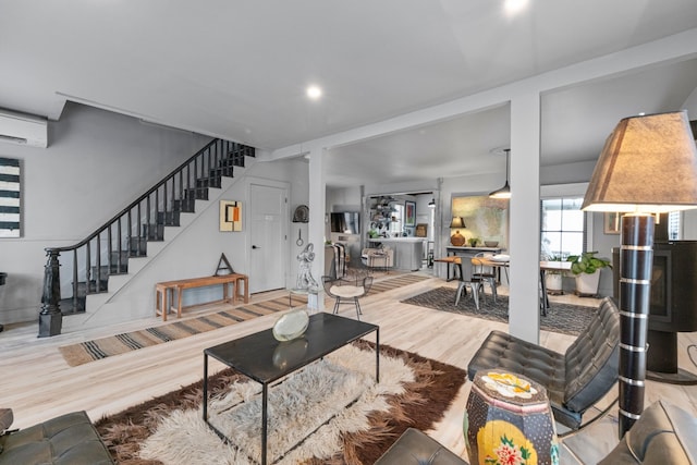 living room with hardwood / wood-style floors and an AC wall unit