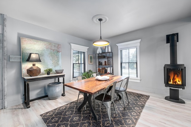 dining room with light wood-type flooring and a wood stove