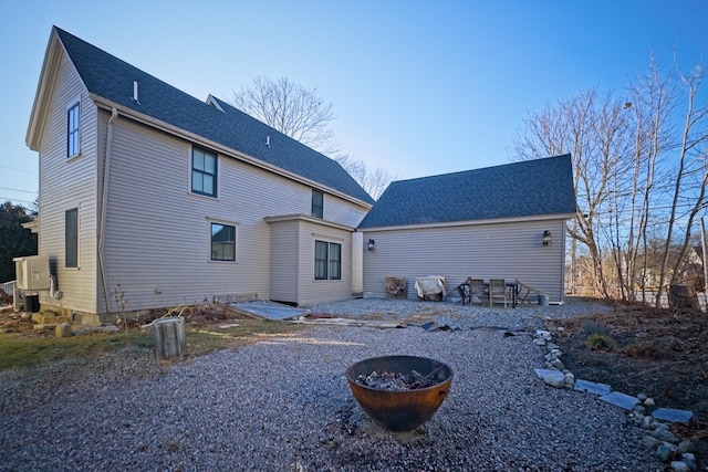 back of house featuring a fire pit and cooling unit