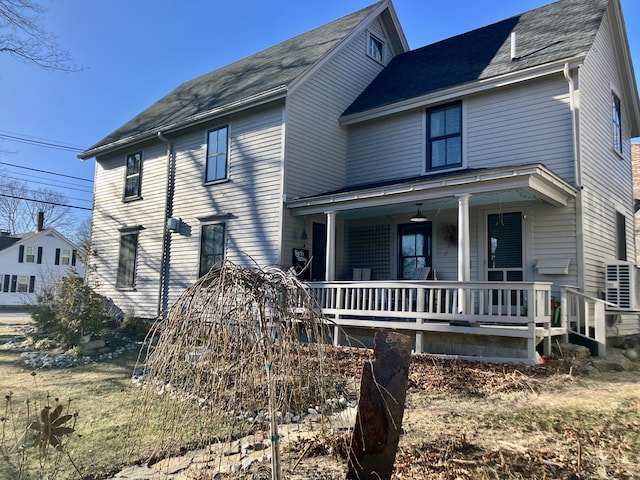 view of front of house featuring roof with shingles, covered porch, and ac unit