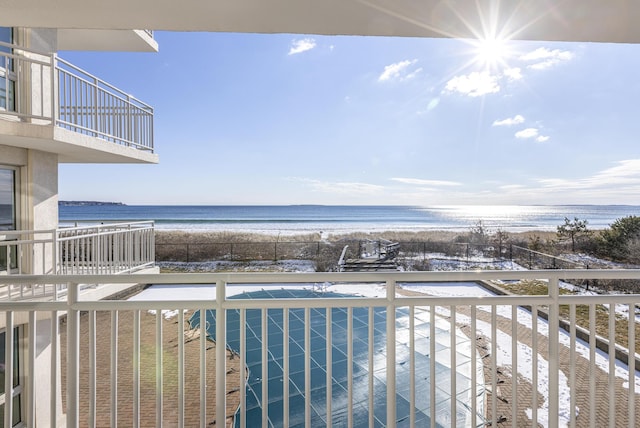 balcony featuring a beach view and a water view