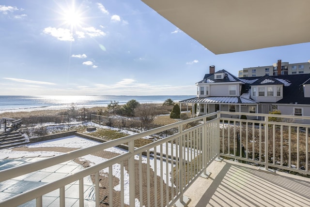 balcony featuring a beach view and a water view