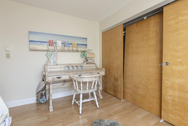 office area with a textured ceiling and light hardwood / wood-style flooring