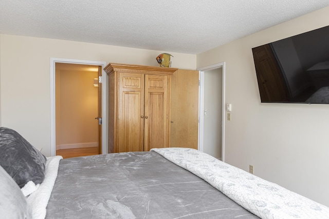 bedroom with a textured ceiling and a closet