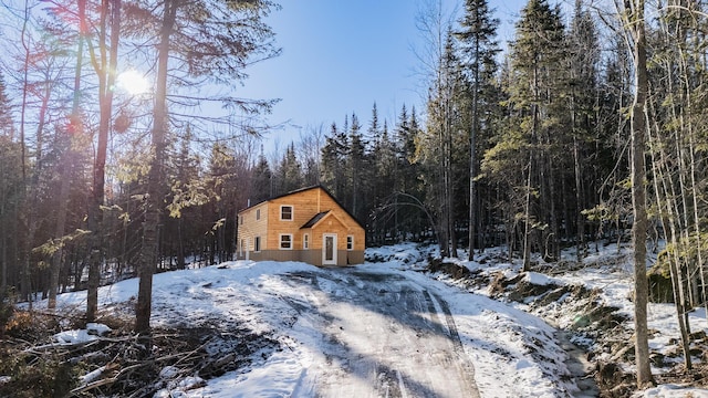 view of snowy exterior featuring a forest view