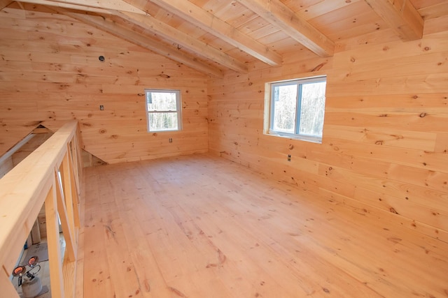 additional living space featuring light wood-style flooring, wooden ceiling, vaulted ceiling with beams, and wooden walls