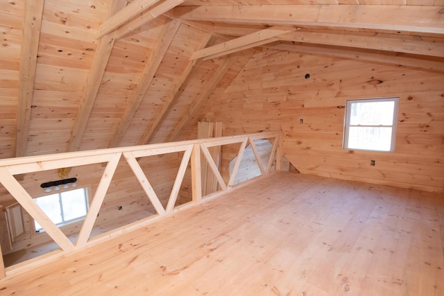 bonus room featuring lofted ceiling with beams, wood ceiling, wooden walls, and wood finished floors