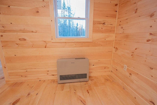 interior space featuring wood walls, wood finished floors, and heating unit