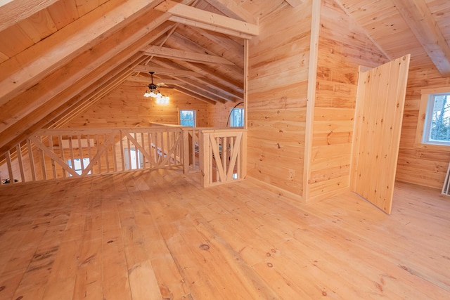 bonus room with hardwood / wood-style flooring, wooden walls, and vaulted ceiling