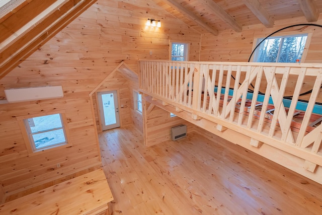 interior space featuring lofted ceiling with beams, hardwood / wood-style floors, wood ceiling, and wooden walls