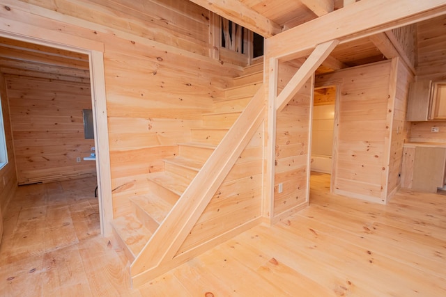 stairs featuring wood walls and hardwood / wood-style flooring