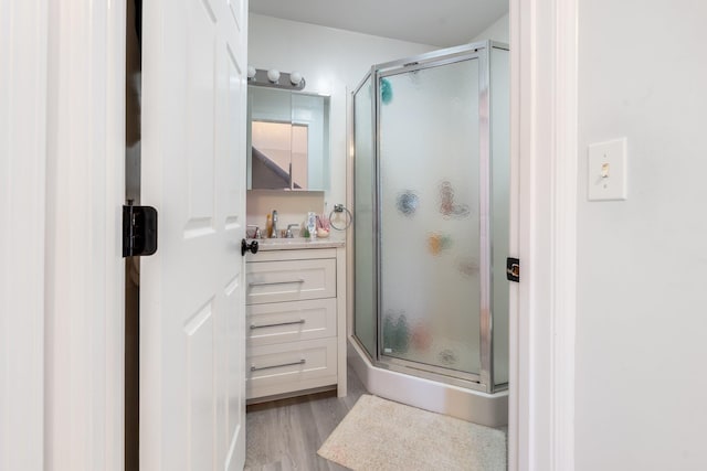 bathroom with vanity, an enclosed shower, and hardwood / wood-style flooring