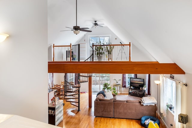 living room with ceiling fan, light wood-type flooring, and vaulted ceiling