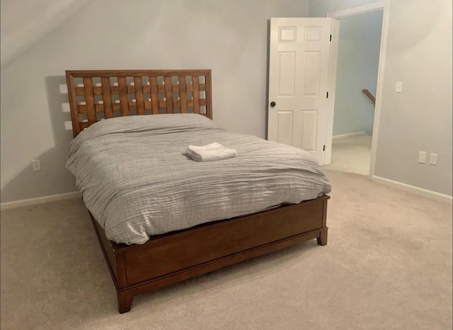 bedroom featuring light colored carpet and vaulted ceiling