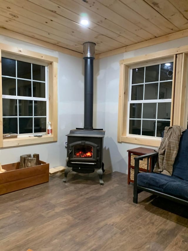 sitting room featuring hardwood / wood-style floors, a wood stove, and wood ceiling