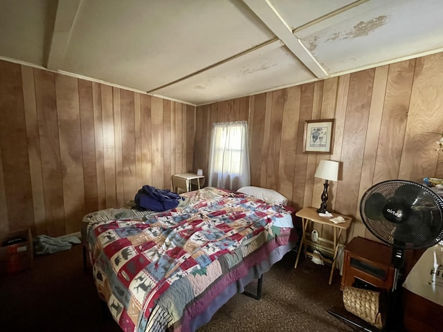 bedroom with dark carpet and wooden walls