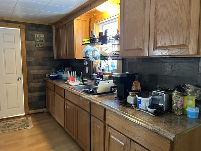 kitchen featuring wood walls, sink, and light hardwood / wood-style floors