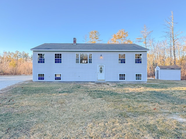 back of house featuring a yard and a shed