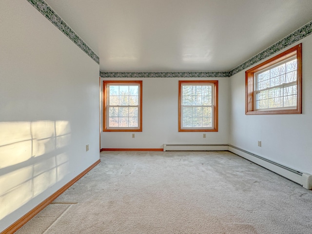 carpeted empty room with a baseboard heating unit