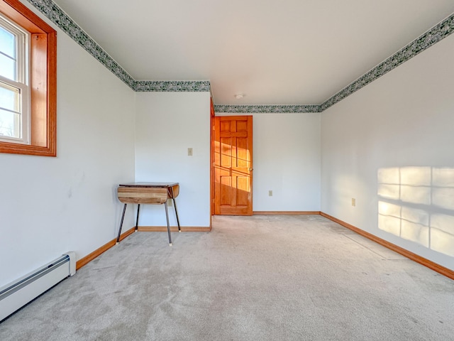 spare room featuring light colored carpet and baseboard heating