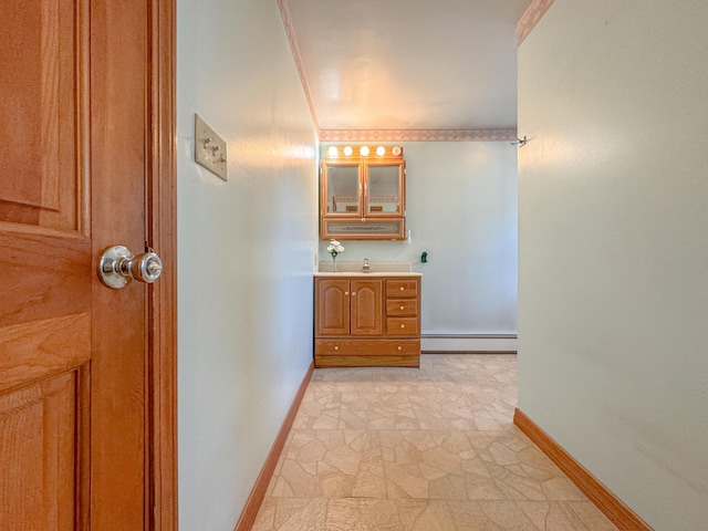 bathroom with vanity, crown molding, and a baseboard heating unit