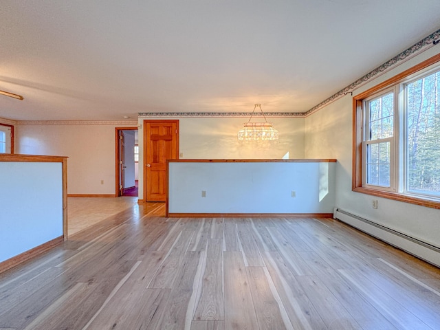 unfurnished room with a chandelier, light hardwood / wood-style floors, and a baseboard radiator