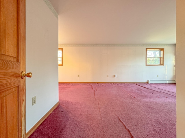 unfurnished room with baseboard heating, crown molding, and carpet floors