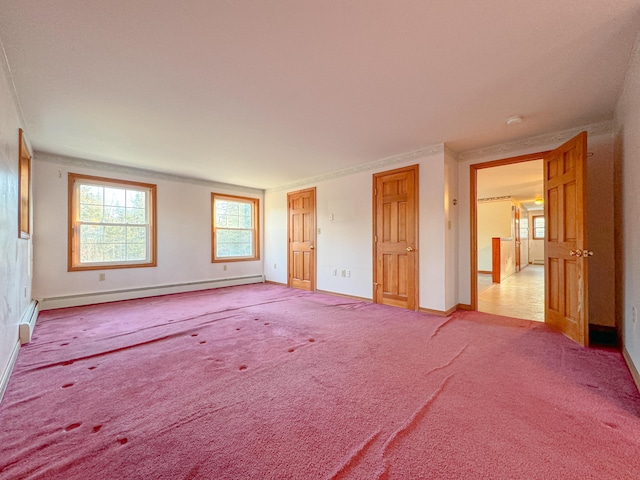 unfurnished bedroom with light carpet and a baseboard heating unit