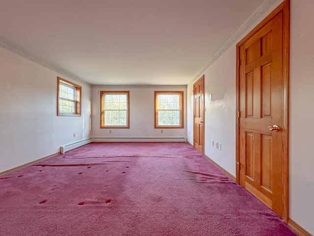 carpeted spare room featuring a wealth of natural light and a baseboard radiator