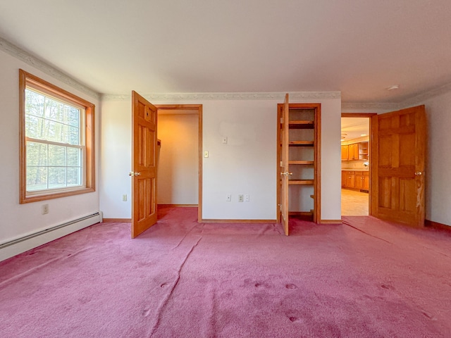 unfurnished bedroom featuring carpet floors and a baseboard heating unit