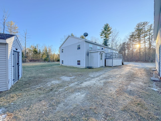 view of side of home with a garage, an outbuilding, and a deck