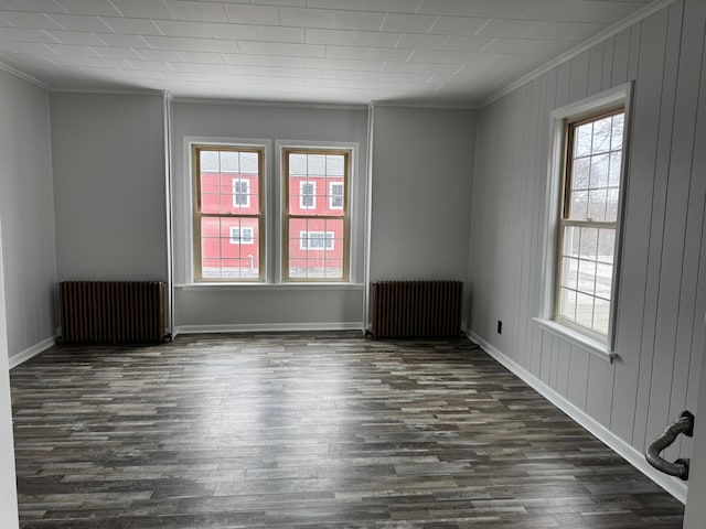 empty room featuring radiator heating unit and crown molding