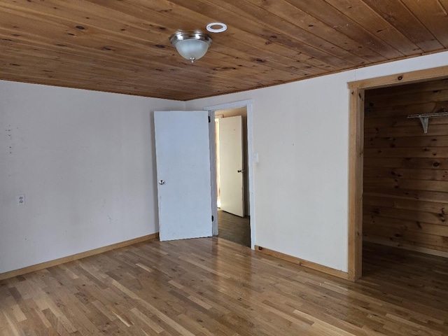 spare room featuring wood-type flooring and wooden ceiling