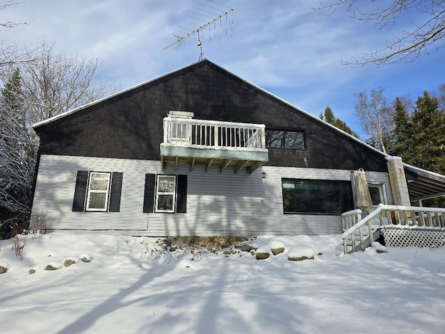 snow covered property featuring a balcony