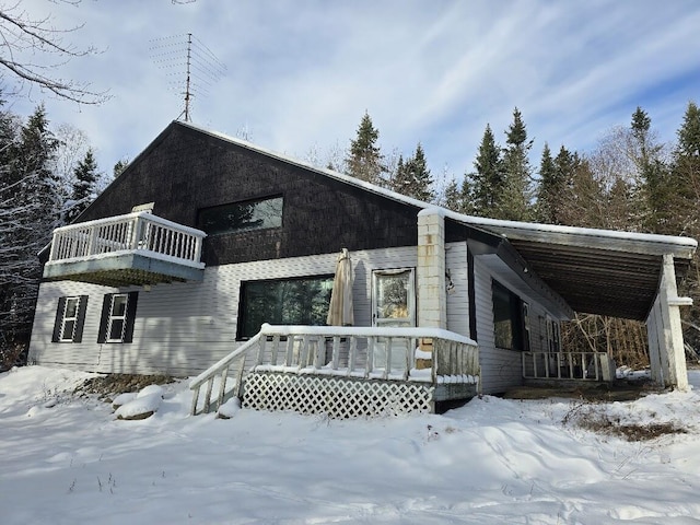 snow covered property featuring a balcony