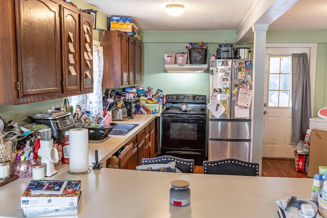 kitchen with stainless steel refrigerator, electric range, dark wood-type flooring, ventilation hood, and a textured ceiling