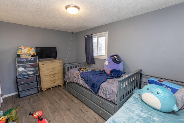 bedroom featuring dark wood-type flooring and a textured ceiling