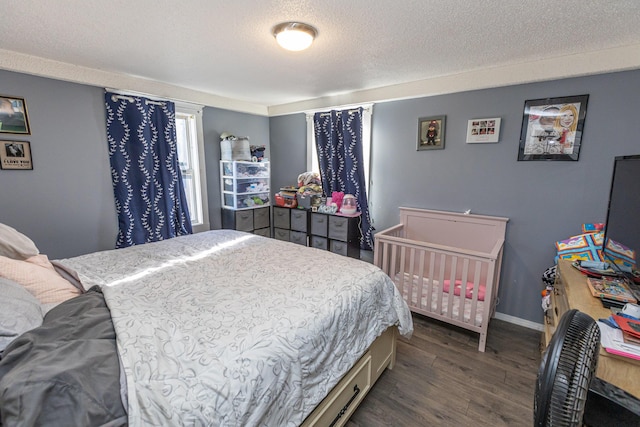 bedroom featuring a textured ceiling and dark hardwood / wood-style flooring