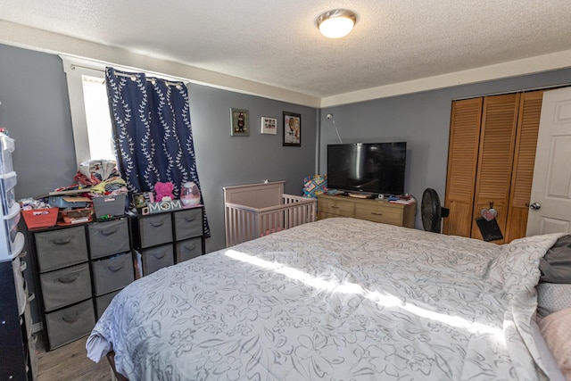 bedroom featuring a closet, hardwood / wood-style floors, and a textured ceiling