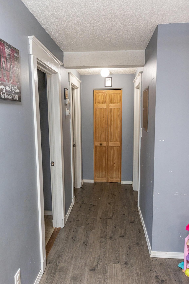 hall with electric panel, dark hardwood / wood-style floors, and a textured ceiling