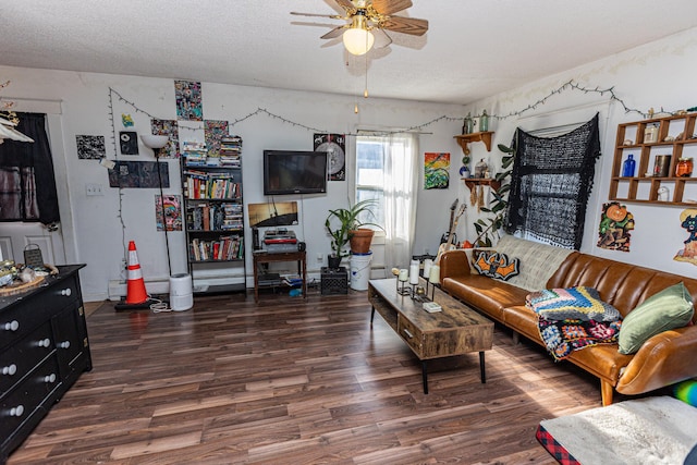 living room featuring ceiling fan, dark wood-type flooring, and a textured ceiling