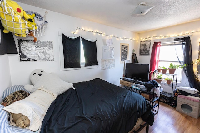 bedroom with wood-type flooring and a textured ceiling