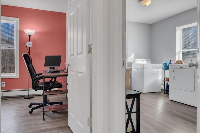 office space with separate washer and dryer, light hardwood / wood-style flooring, and a baseboard heating unit