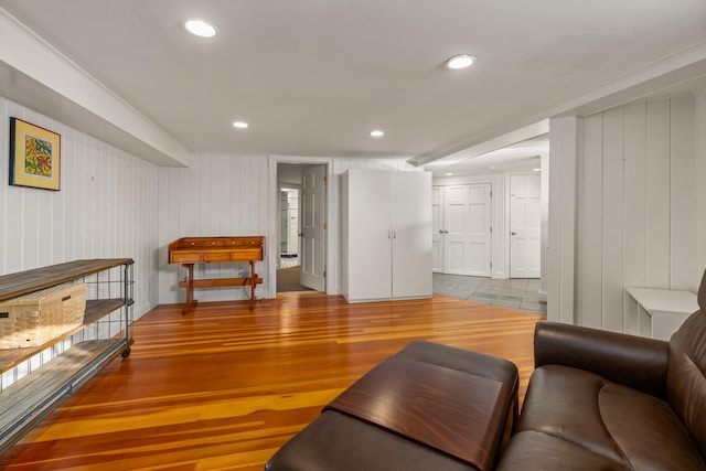 living room featuring wood-type flooring and crown molding