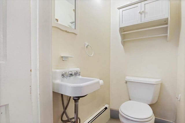 bathroom featuring toilet, a baseboard heating unit, and sink